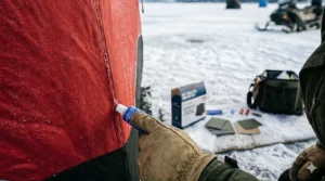 Alt text for image 4: Applying waterproof sealant from a repair kit to an ice shelter seam.