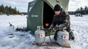 Réservoir de propane de 20 lb raccordé à une chaufferette dans une cabane de pêche.