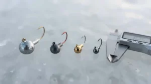 A side-by-side size comparison of tungsten vs lead jigs for ice fishing.
