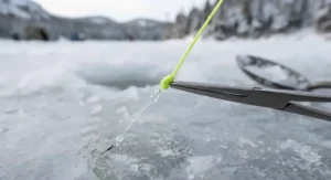 A detailed knot setup connecting braided ice fishing line to a clear fluorocarbon leader for cold water transparency.