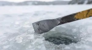 The sharp, heavy-duty steel blade of an ice chisel for safety designed for thick winter ice.