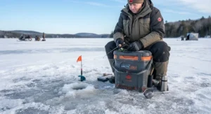 An insulated ice fishing bucket with a comfortable padded cushion lid used as a seat.